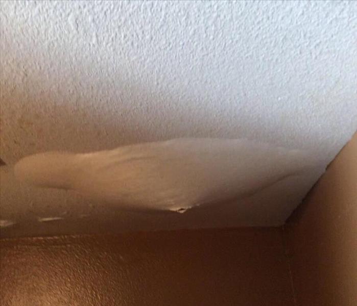 Ceiling with a water bubble in it that is dripping